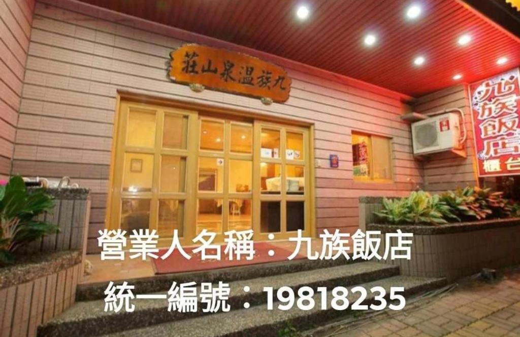un ristorante con un cartello sulla parte anteriore di 九族飯店 臺東縣旅館004號 a Wenquan