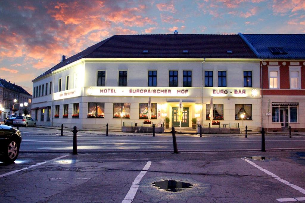 un grande edificio bianco con un negozio in una strada di Hotel Europäischer Hof a Elsterwerda