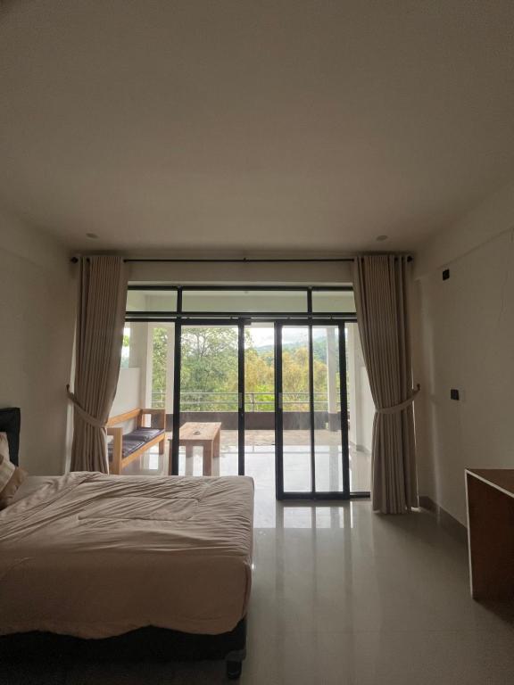 a bedroom with a bed and a sliding glass door at jungle senaru cottage in Senaru