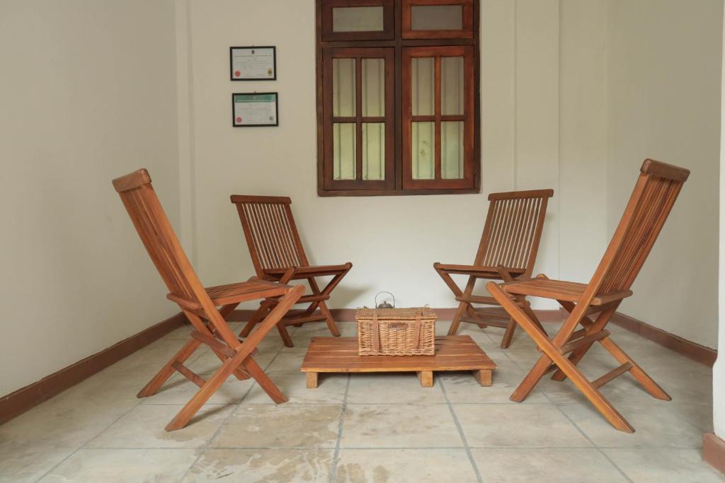 three rocking chairs and a table in a room at Self Cate Luxury Apartments in Kandy