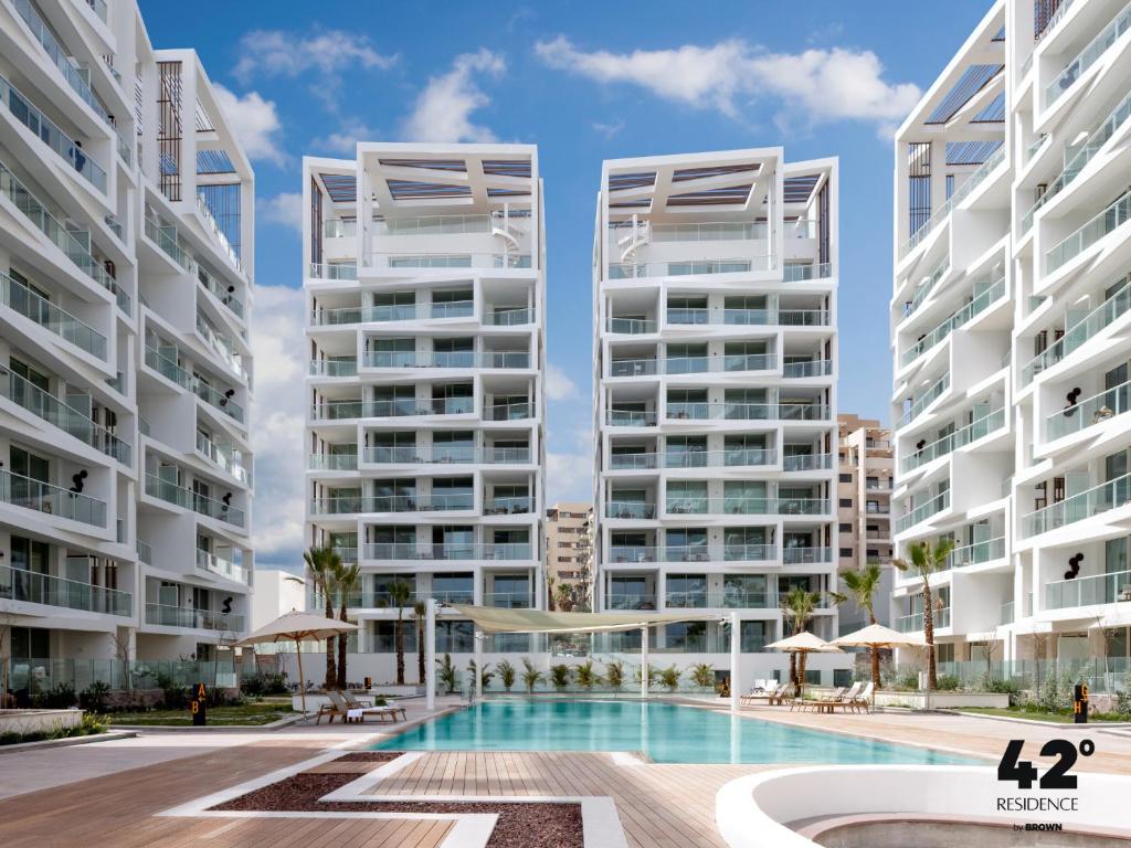 een afbeelding van twee hoge appartementengebouwen met een zwembad bij 42 Residence by Brown in Eilat