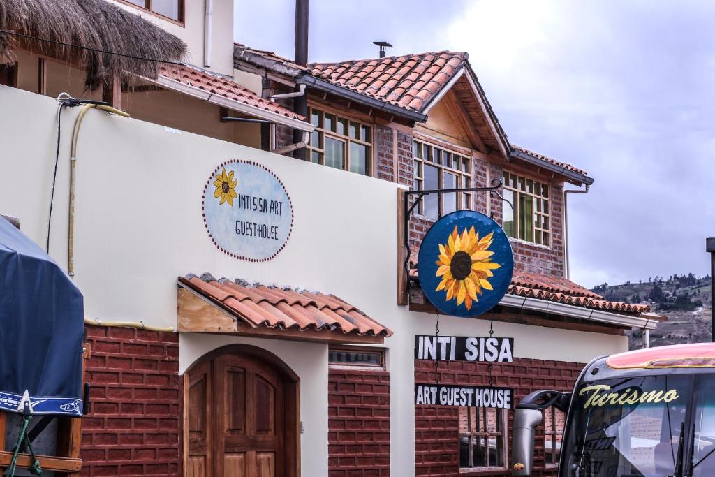 a building with a sunflower sign on the side of it at Inti Sisa Art Guesthouse in Guamote