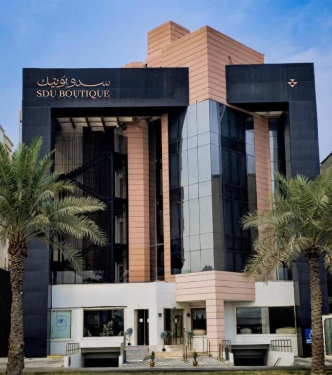 a building with palm trees in front of it at سدو بوتيك الخبر in Al Khobar