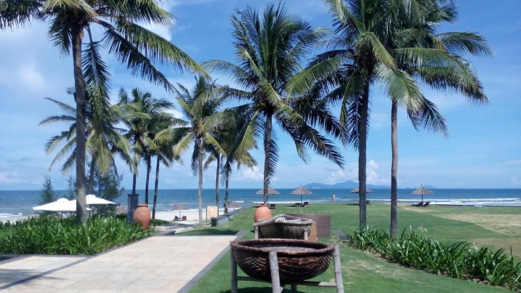 a park with palm trees and a beach at Ocean Apartment Spa & Golf Danang in Danang