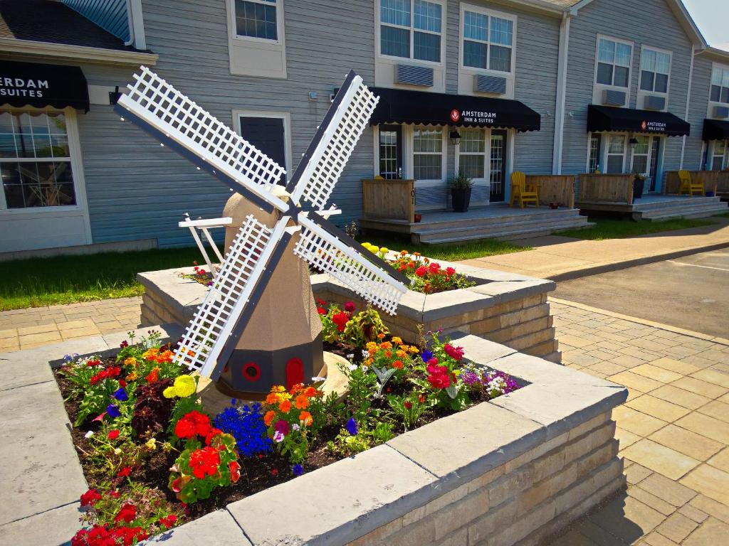 una statua di un mulino a vento in un giardino fiorito di Amsterdam Inn & Suites Moncton a Moncton