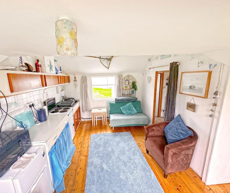 eine Küche mit Herd und eine Couch in einem Zimmer in der Unterkunft Oceans End in Bacton