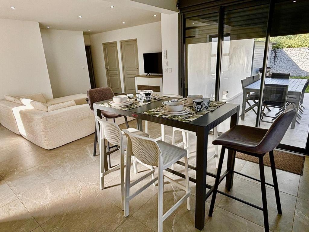 a dining table and chairs in a living room at LA RDC Villa 3 ch jacuzzi Saint-Pierre in Saint-Pierre