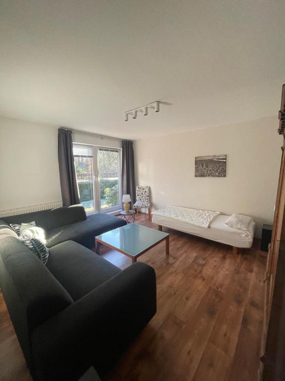 a living room with a couch and a table at Hamburger Villenviertel, ganzes Haus mit 5 Einbettzimmern,1 Esszimmer in Hamburg