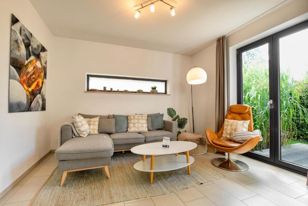 ein Wohnzimmer mit Sofa und Tisch in der Unterkunft Strandhaus Bernsteinsammler in Ostseebad Sellin