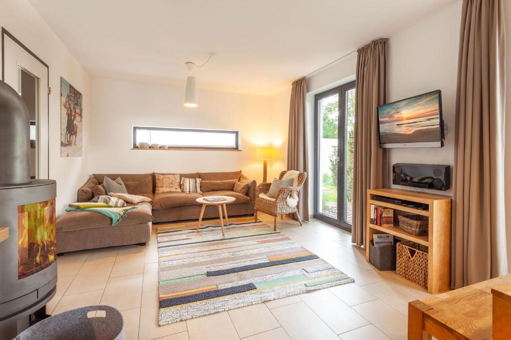 a living room with a couch and a tv at Strandhaus Wolkenlos in Ostseebad Sellin