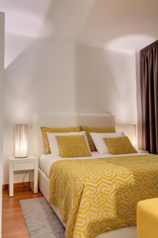 a bedroom with two beds with yellow and white sheets at Bracara Guest House "Campo Novo" in Braga