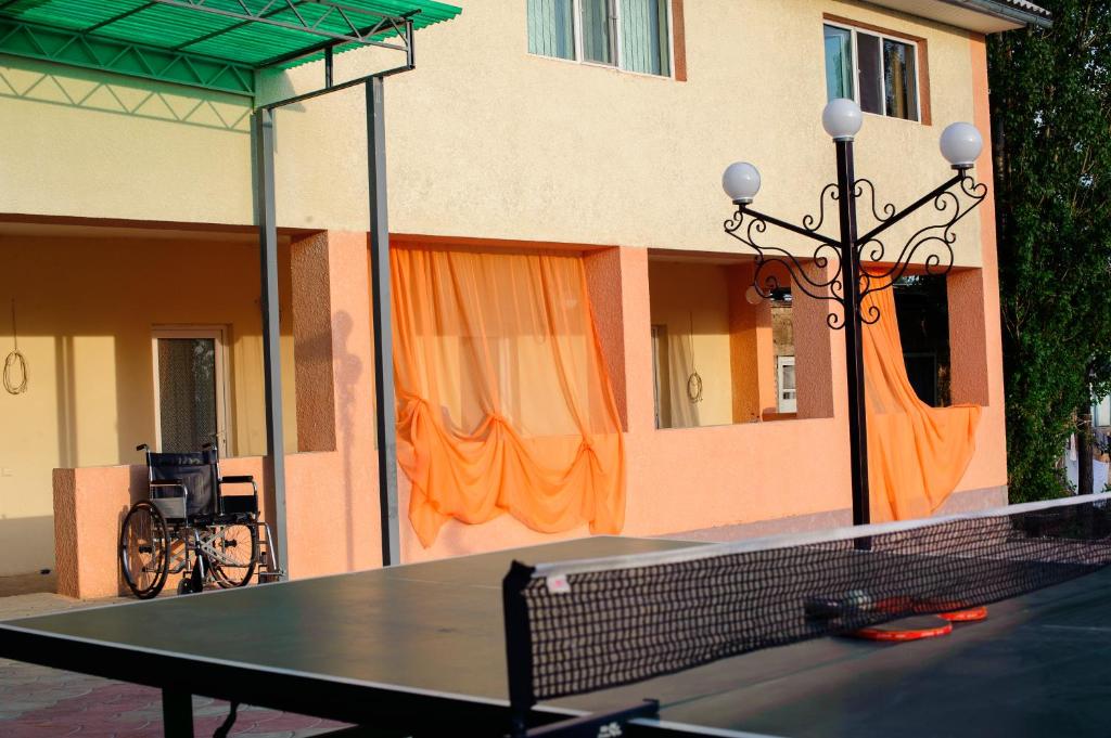 a ping pong table in front of a building at Guest House Issyk-Kul Nomad in Bosteri