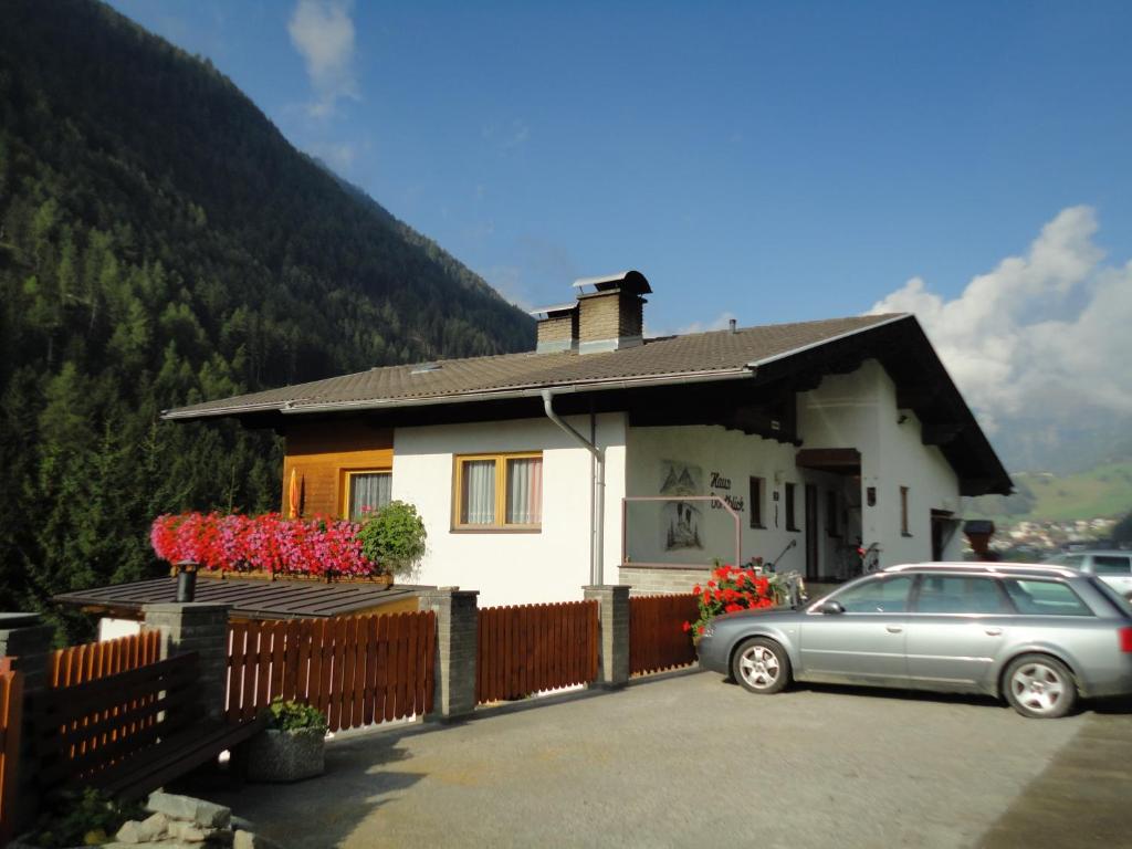 une maison avec une voiture garée devant elle dans l'établissement Haus Dorfblick, à Prägraten am Großvenediger