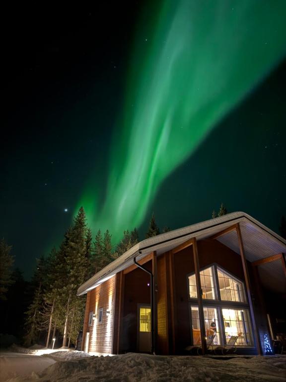 a cabin with the aurora in the sky at Villa Raanujärvi in Romakkaniemi