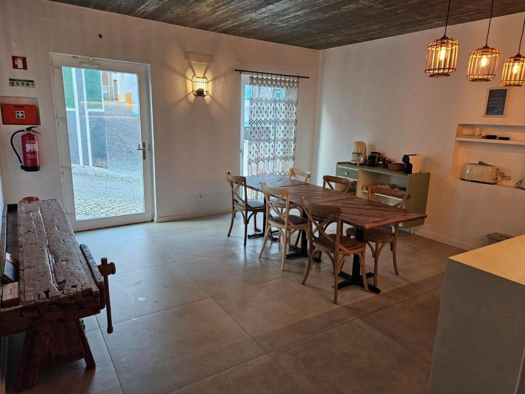 a dining room with a wooden table and chairs at Sunset Guesthouse - Costa Vicentina in Aljezur