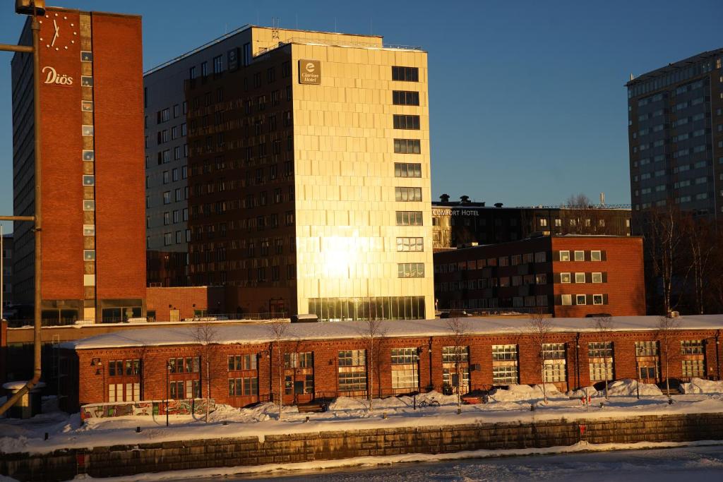 a brick building in front of some tall buildings at Clarion Hotel Umeå in Umeå