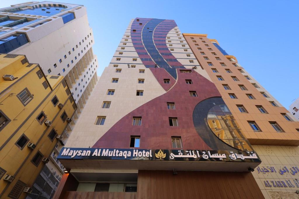 a building with a mural on the side of it at Maysan AL Multaqa Hotel in Al Masfalah