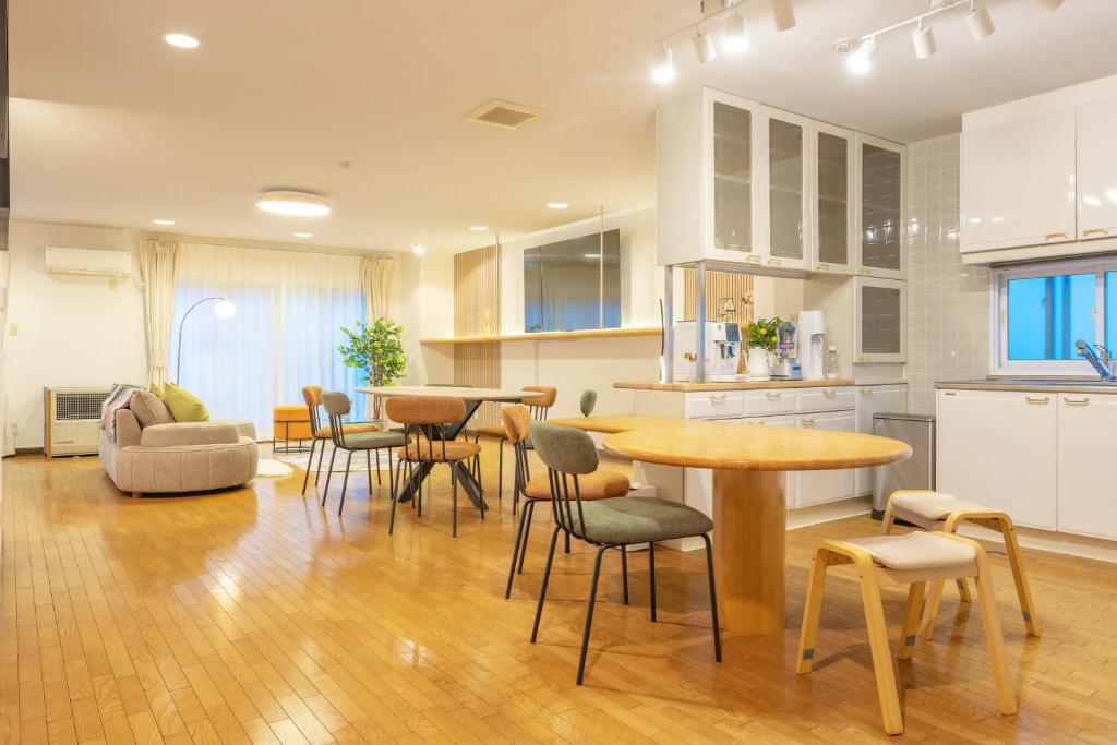 a kitchen with tables and chairs in a room at Cozy Stay Kamui in Asahikawa