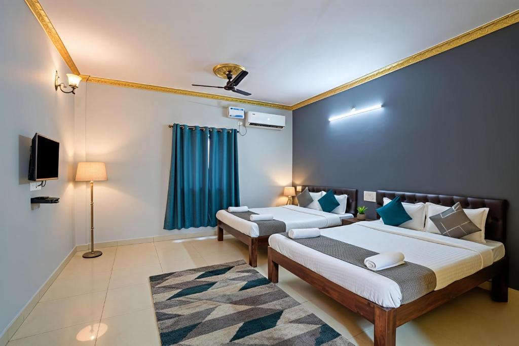 a bedroom with two beds and a television in it at RAIAl DWELLING PLACE in Calangute