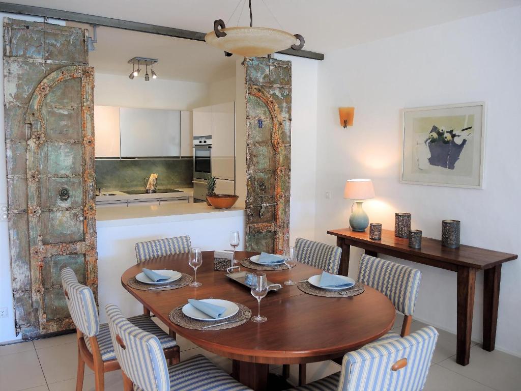 a dining room with a wooden table and chairs at Residenza Golf Parco by Fewotessin in Ascona