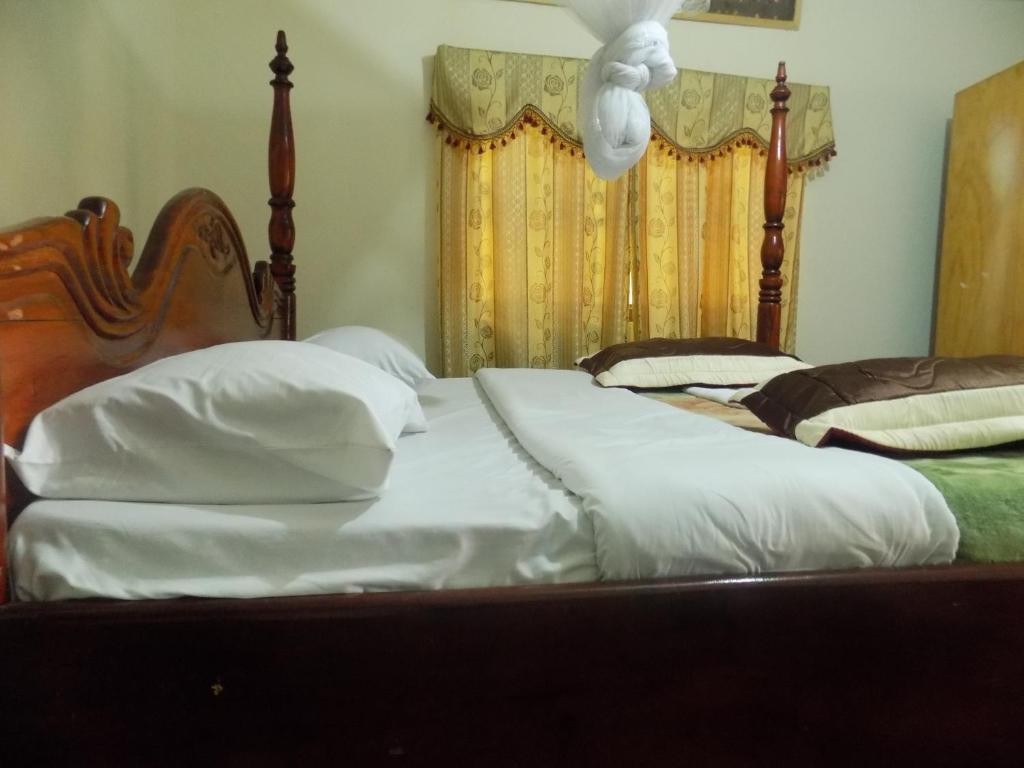 a bedroom with two beds with white pillows at Townview Hotel Mubende in Mubende