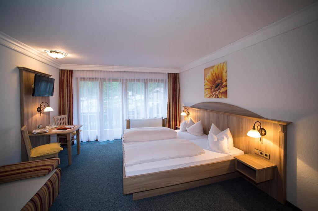 Postel nebo postele na pokoji v ubytování Aktivhotel & Gasthof Schmelz Ihr Urlaubs Hotel in Inzell mit Wellness Hallenbad, Alpensauna & Dampfbad