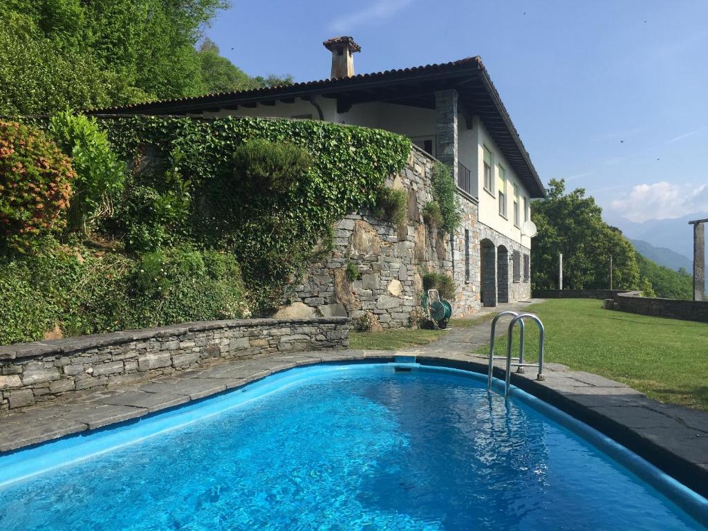 a swimming pool in front of a house at La Civetta by Fewotessin in Brissago