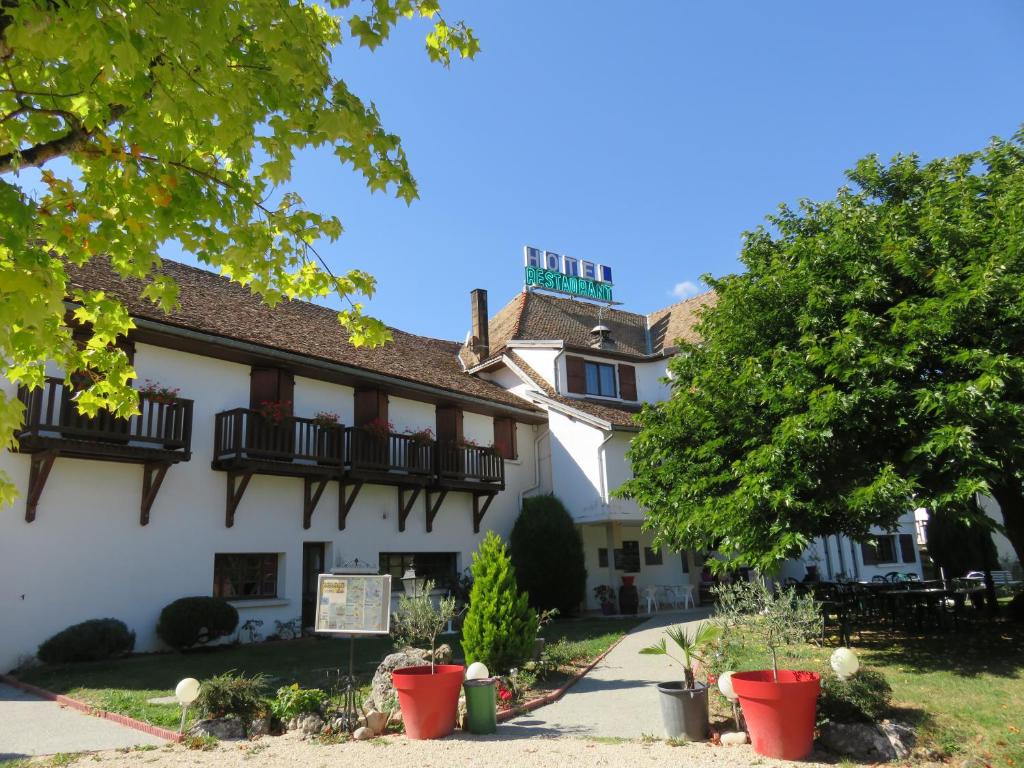 a large white building with balconies and trees at Hotel Restaurant Le Traineau in Clelles