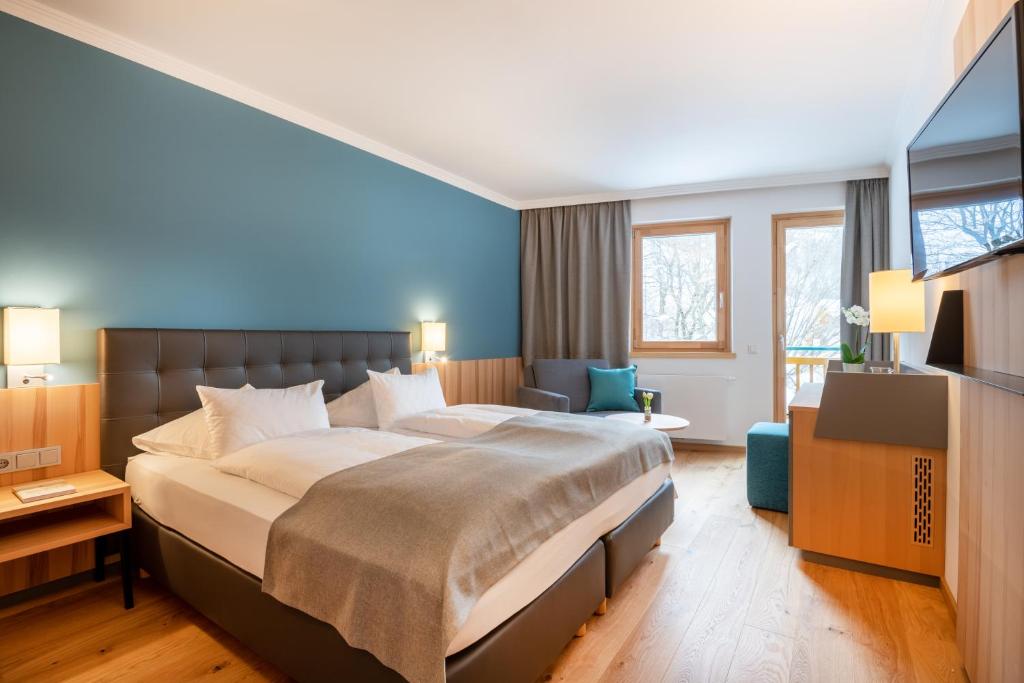 una camera d'albergo con un letto grande e una finestra di Familien- Sportresort BRENNSEEHOF a Feld am See