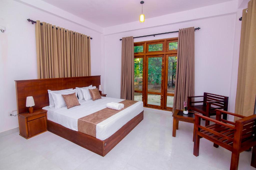 een slaapkamer met een groot bed en een raam bij Ayana Resort Wilpattu in Anuradhapura