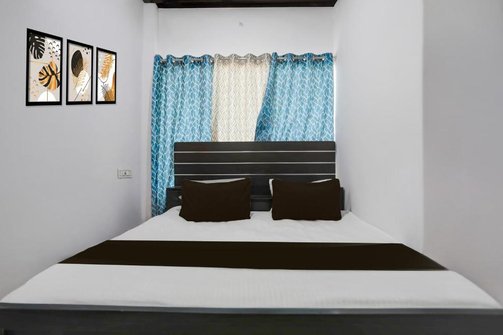 une chambre avec un grand lit avec des rideaux bleus dans l'établissement Hotel O stay inn, à Shivāpur