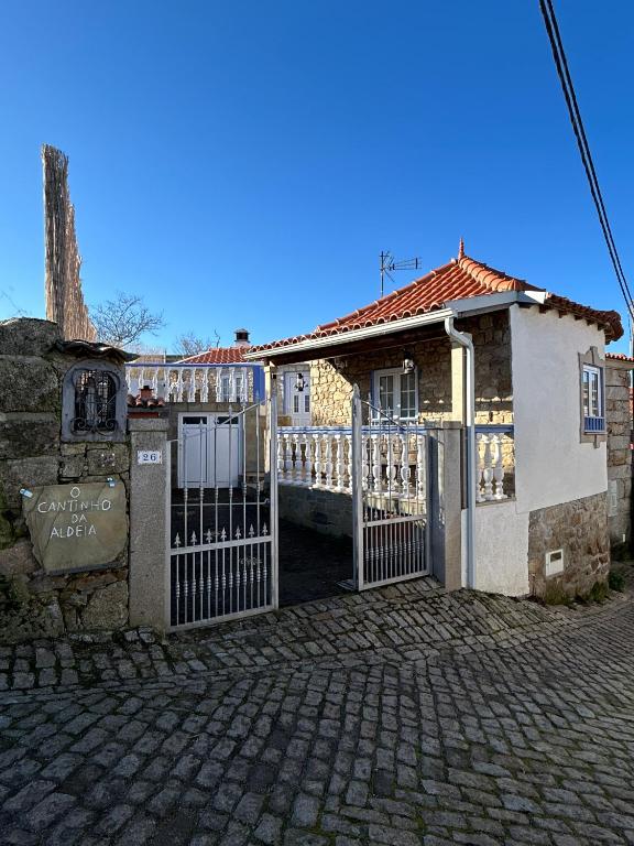 an old building with a gate in front of it at Cantinho da Aldeia in Castedo