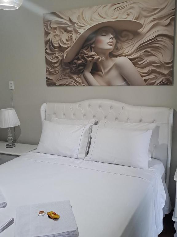 un letto con l'immagine di una donna con un cappello di Hospedagem Altas da Quitéria Suíte 02 a Catas Altas