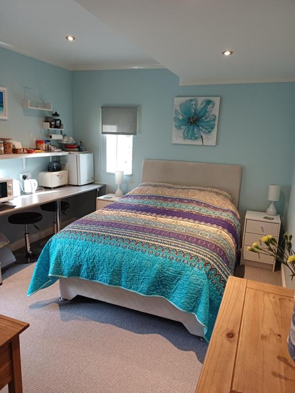 ein Schlafzimmer mit einem Bett und einem Schreibtisch in der Unterkunft Santi Bhavana Bed & Breakfast in Westbury