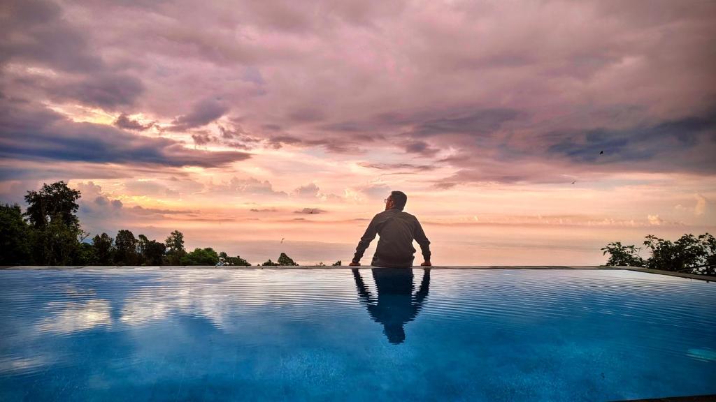 a man standing in front of a pool of water at Munduk Pondok Canopee in Ambengan