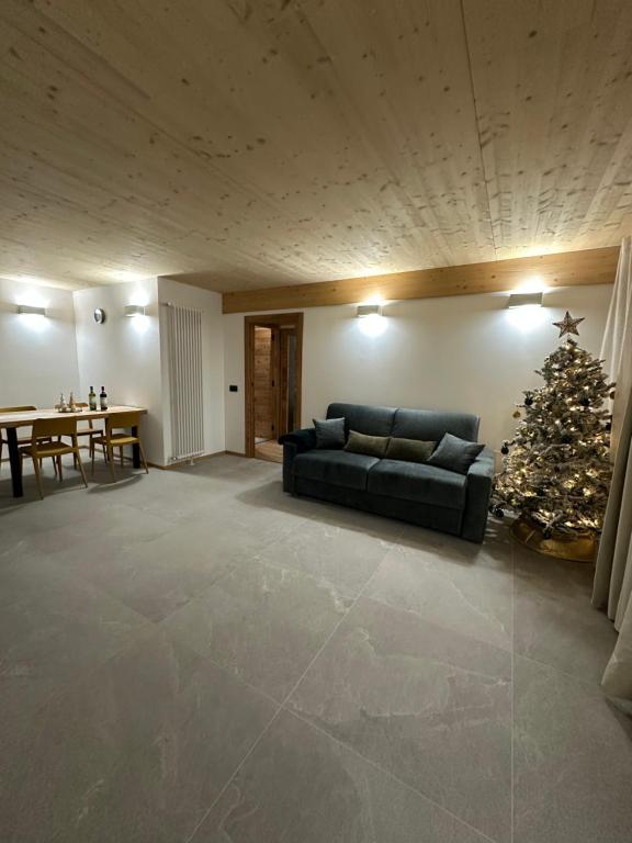ein Wohnzimmer mit einem Weihnachtsbaum und einer Couch in der Unterkunft Maison ValGià in Champoluc
