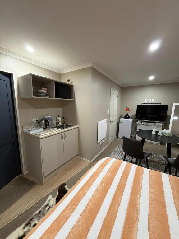 a living room with a kitchen and a dining room at Casa Miguelle a Private mini house in Dunedin