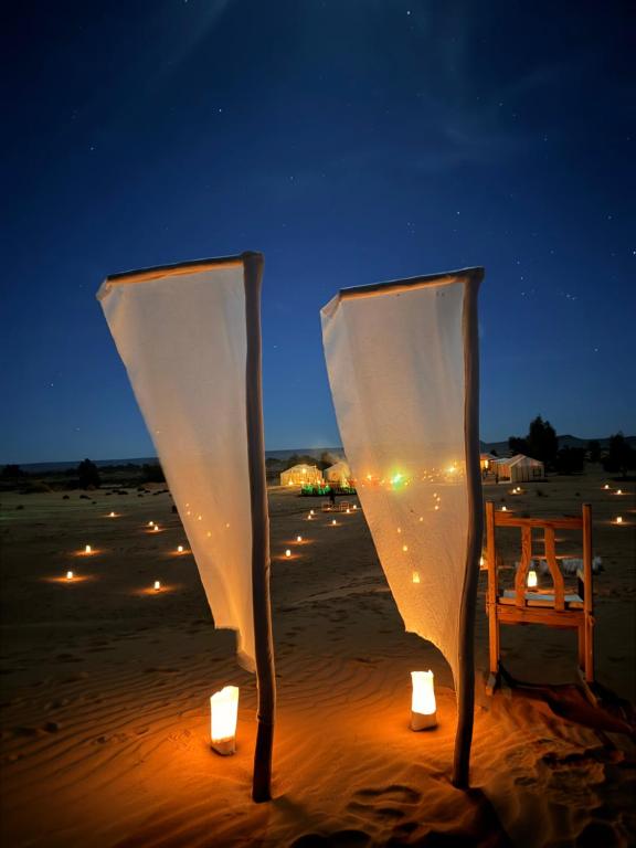 candele accese sulla spiaggia di notte di Horaz Merzouga Camp a Merzouga