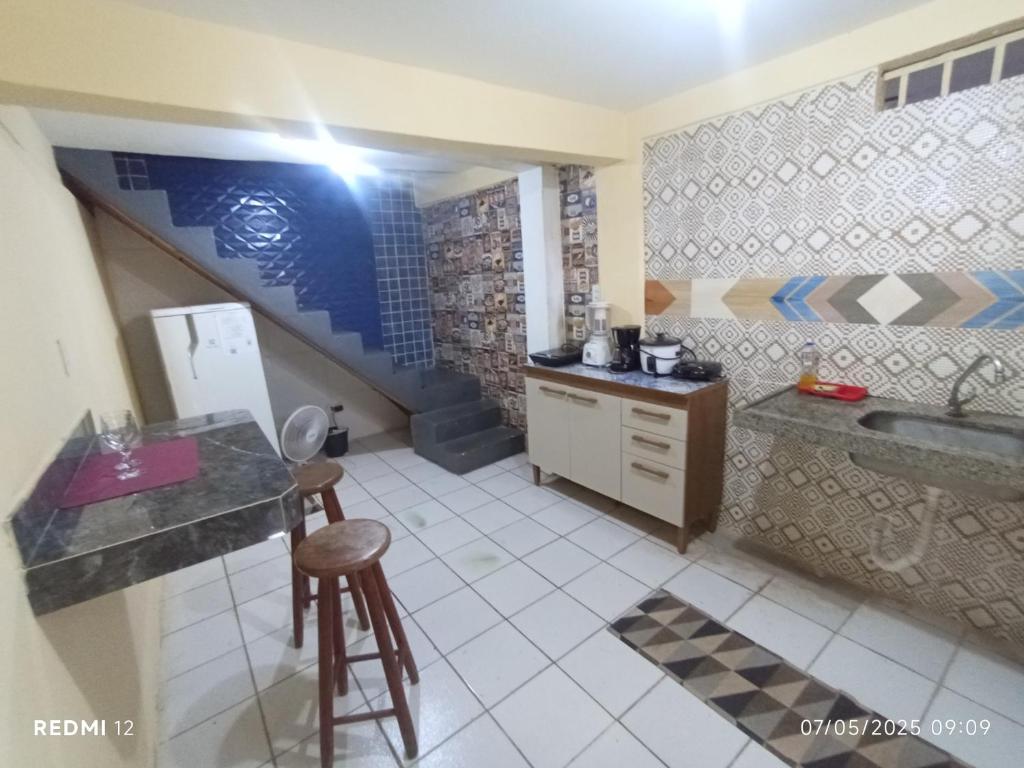 a kitchen with a counter and a sink and a refrigerator at kitnet A in São Luís