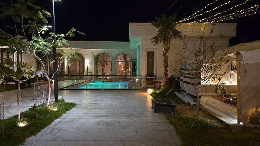 a house with a swimming pool at night at منتجع آركو ARCO Resort in Al Wudayy