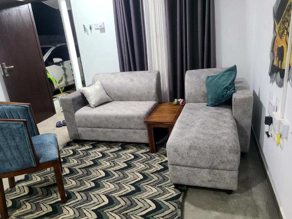 a living room with two chairs and a chair and a table at Seven S villa in Kamburugamuwa