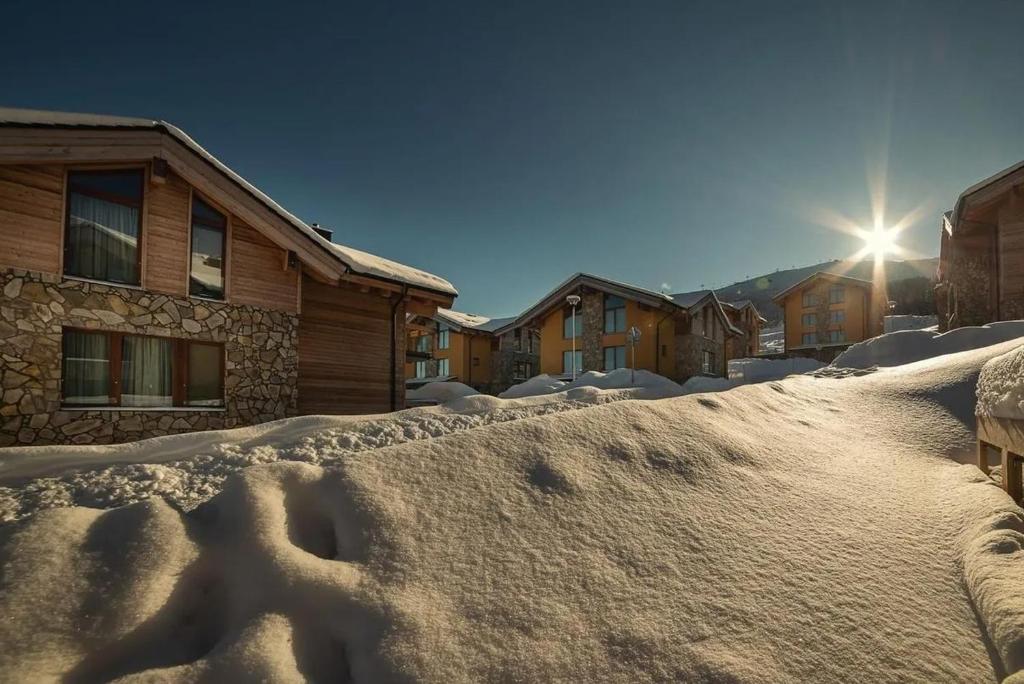 een berg sneeuw voor een huis bij Chalets Jasná Centrum APARTMENT M - Free Jacuzzi & Sauna and Chopok view in Demanovska Dolina