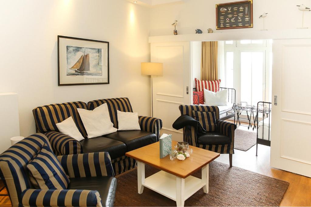 een woonkamer met een bank, stoelen en een tafel bij Dünenschloss - 02-24 in Kühlungsborn