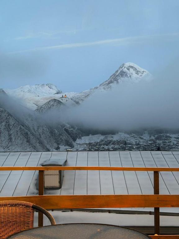 a table with a view of a snowy mountain at Luno Cottage in Kazbegi