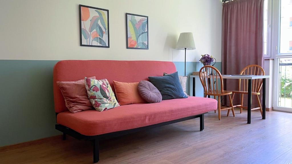 a red couch with pillows on it in a living room at Wygodne mieszkanie dla dwojga in Bystrzyca Kłodzka