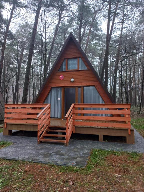 een klein huis met twee banken ervoor bij Czapla in Bocheniec