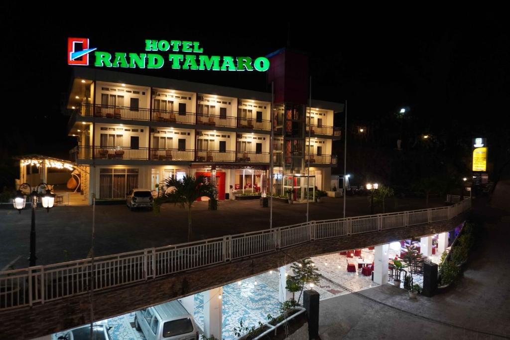 a hotel with a sign in front of a building at Grand Tamaro Hotel in Parapat