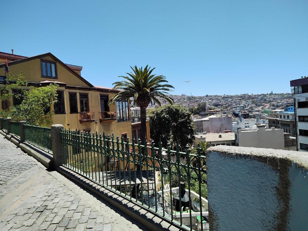 een hek voor een huis met een palmboom bij De Gino Hostal in El Cerrillo