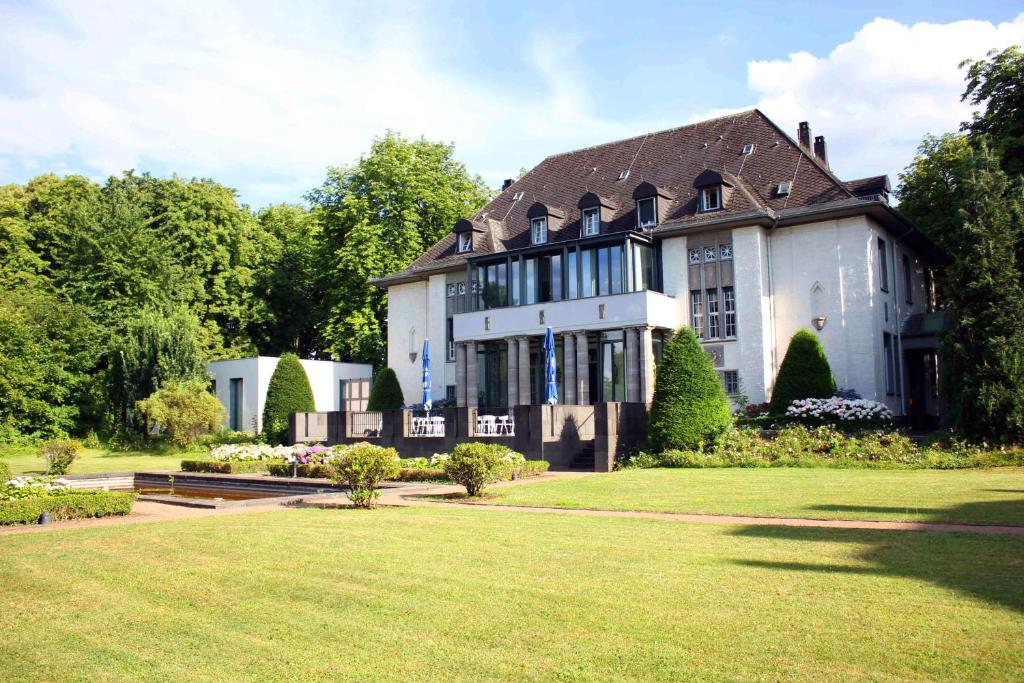 a large white house with a large yard at Villa Weisser Berg in Neuwied