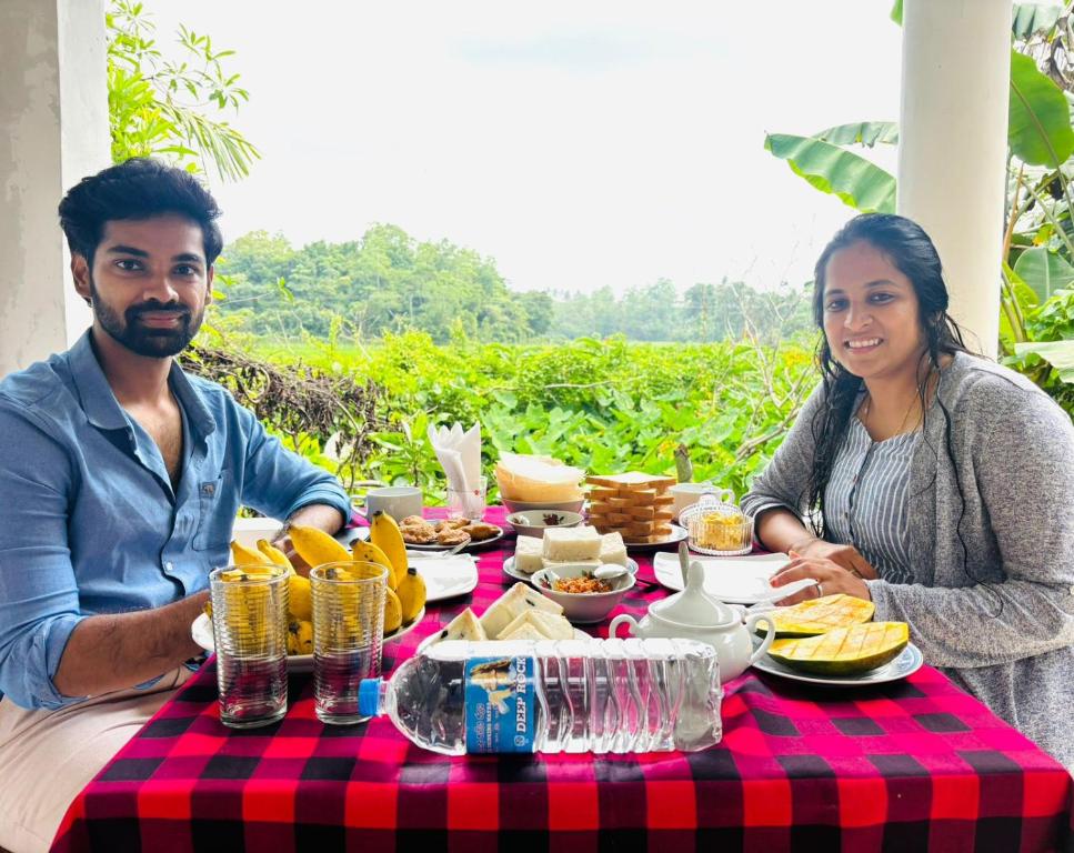 a man and woman sitting at a table with food at My Guest Mirissa in Mirissa